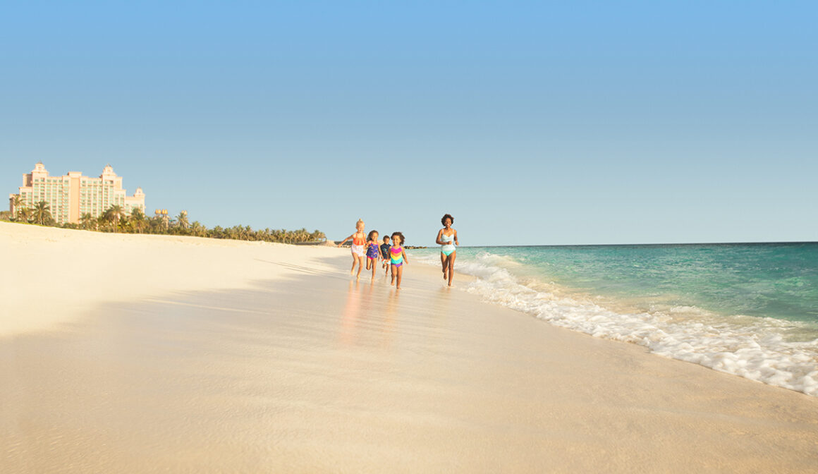 two girls on the beach ocean water splashing sand bikini bathing suit swimming playing guests girls people sun family running on beach sand kids family mom mother kids