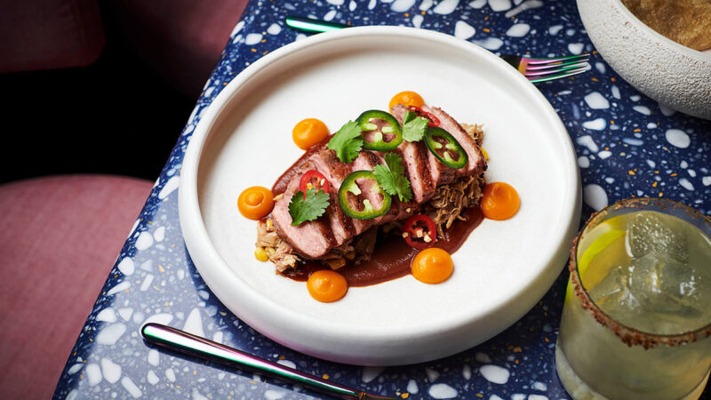 A dish and a margarita on a table at Pink Agave. Pink Agave vv.com gallery update oct 2021