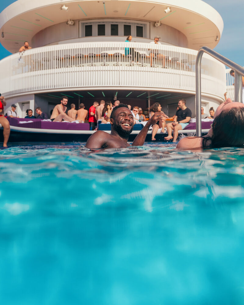 Man smiling and squinting into the sun in the Aquatic Club pool. @thefraserjames